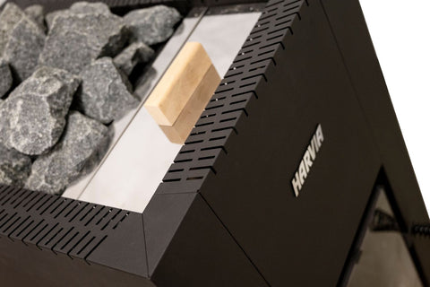Black Harvia Linear 22 wood-burning sauna stove with gray stone rocks in top basin, visible flames in front firebox, and side