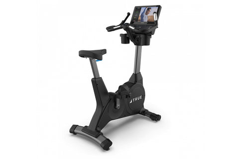 TRUE CS400 black upright exercise bike with gray frame, digital display console, and foot pedals on white background