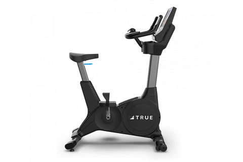 TRUE CS400 black upright exercise bike with gray frame, digital display console, and foot pedals on white background