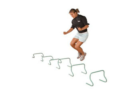 Model jumping over green agility hurdles while wearing black short-sleeve shirt and light blue shorts