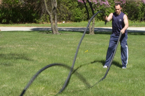 Black twisted battle ropes coiled with four extended strands on white background