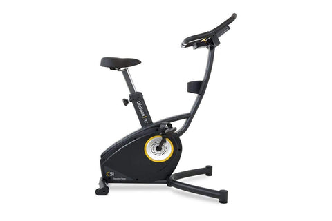 Black upright exercise bike with yellow and gray resistance wheel, black padded seat and handlebars, displayed on white backg