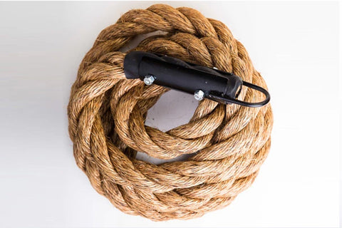 Coiled natural manila climbing rope with black handles, flat lay on white background