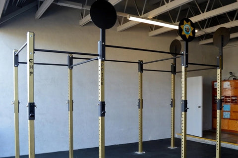 Warrior Commercial Pro Intermediate crossfit rig with cream-colored uprights, black pull-up bars, and mounted target balls in