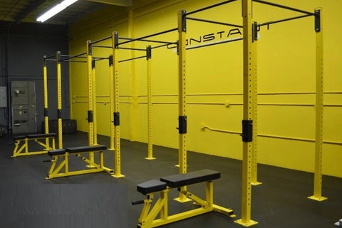 Warrior Commercial Pro Yellow Jacket multi-station gym rig with yellow steel frames, black pull-up bars, and adjustable weigh