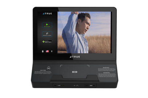 TRUE Envision II black fitness console with 16-inch screen displaying workout video and side menu options on white background