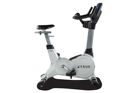 TRUE ES900 upright exercise bike with silver frame, black seat, and digital console, on white background