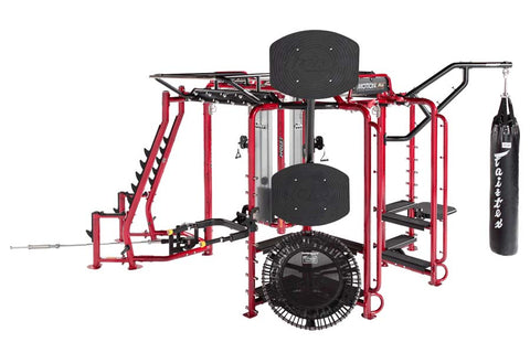 Red and black multi-station gym rig system with cable machines, pull-up bar, heavy bag attachment, and leg press station on w