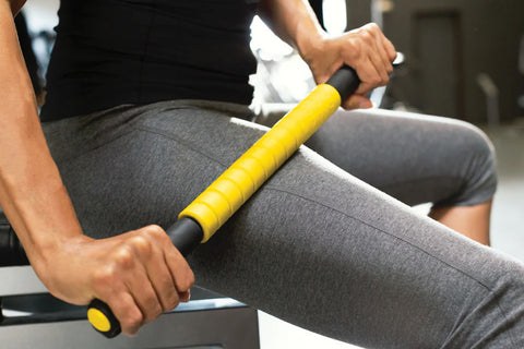 Massage roller with yellow textured center section and black grip handles on white background