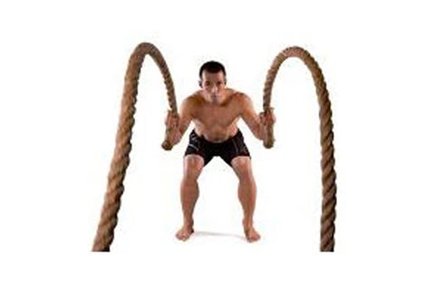 Man using thick brown battle ropes in athletic stance on white background