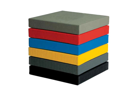 Stacked foam martial arts mats in gray, red, blue, yellow, dark gray, and black on white background