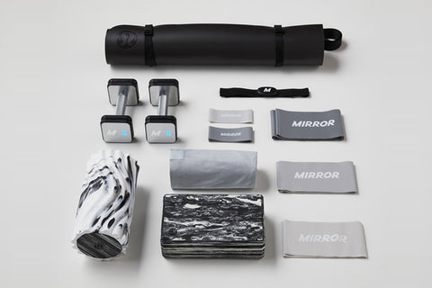 Lululemon Studio Mirror Pro with reflective surface, displayed with accessories including black carrying case, gray yoga mat,