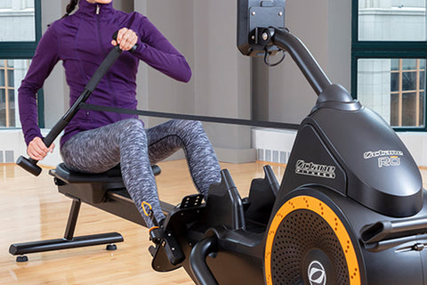 Black recumbent rowing machine with orange accents, digital display console, and adjustable seat on white background