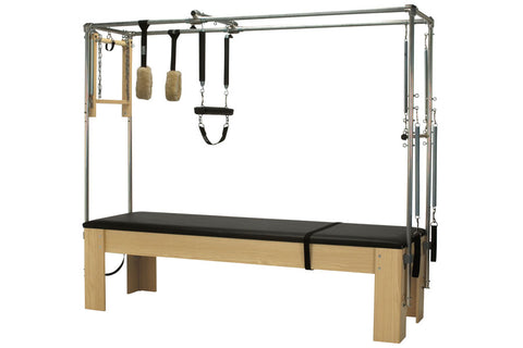 Peak Pilates Premier Cadillac with natural wood base, black padded mat, metal frame with hanging resistance bands and cork fo