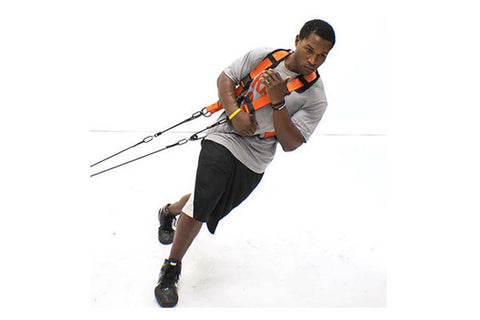 Man wearing orange and black Purmotion Performance Harness with control bar handles during kite action, on white background