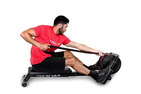 Man wearing red Ropeflex t-shirt and black shorts using black Ropeflex RX2200 horizontal rope trainer on white background