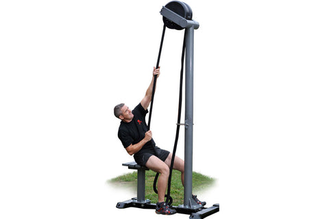 Man using black Ropeflex RX5500 rope trainer machine with tall vertical frame and pulley system on grass