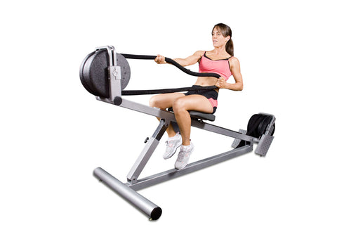 Shirtless man using gray and black incline rope trainer with medicine ball attachment, demonstrating exercise form against wh