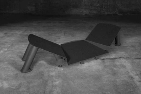 Black SKLZ HyperSquat leg exercise machine with metal cylindrical supports on concrete floor