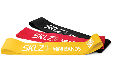 Set of three SKLZ Mini Bands in yellow, red, and black latex loop resistance bands on white background