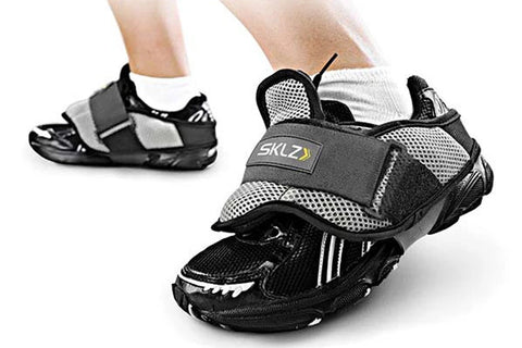 SKLZ shoe weights in black and gray mesh with velcro straps, worn by model with white socks
