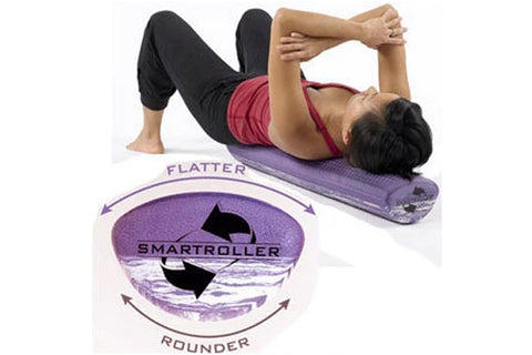 Woman lying on purple convex foam roller demonstrating abdominal exercise, wearing burgundy tank and black capris