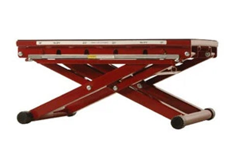Red adjustable plyometric box with X-frame scissor legs, metal top surface, and black rubber feet on white background