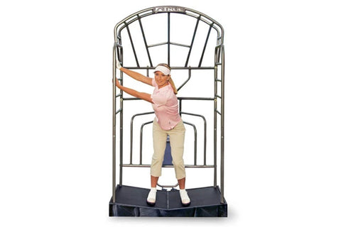 Model wearing pink sleeveless top and beige capris using TRUE Stretch Golf training device with metal frame and black base