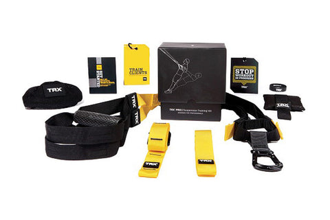 TRX Pro Suspension Training Kit with black straps, yellow and black accessories, instructional guides, and black carrying cas