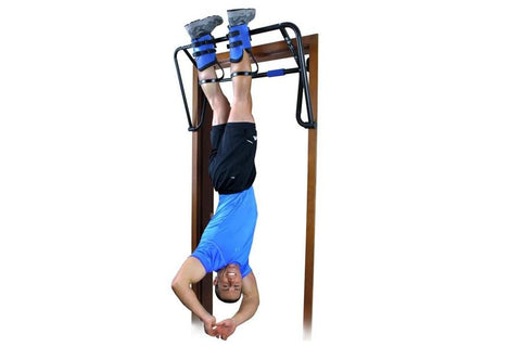 Man performing inverted pull-up on wooden inversion rack with black frame and blue hand grips and leg straps