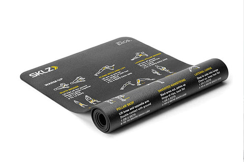 Black SKLZ exercise mat with yellow text and illustrated workout exercises, partially rolled, on white background