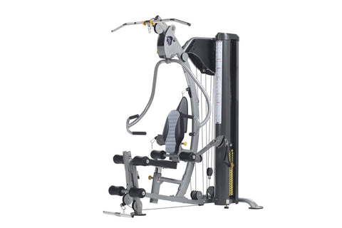 TuffStuff Classic home gym with silver frame, black seat, cable machine arms, and leg press attachment on white background