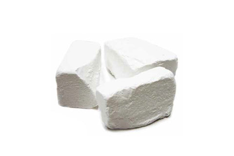 Two white broken chalk pieces on white background, showing rough texture and jagged edges