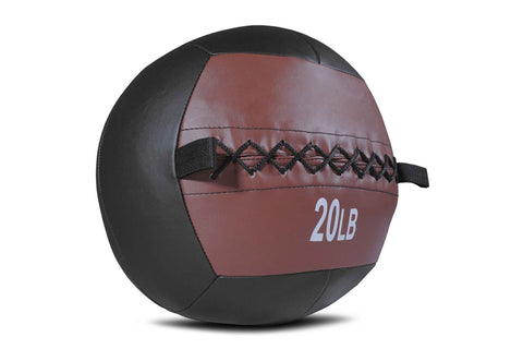 20lb medicine ball with brown leather upper and black rubber lower half on wooden box, next to black resistance training bag 