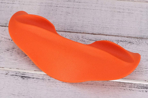 Bright orange foam squat pad with curved design and handles, displayed on whitewashed wood background