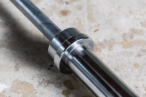 York Elite Power Bar with chrome collar and black grip sleeve on concrete surface