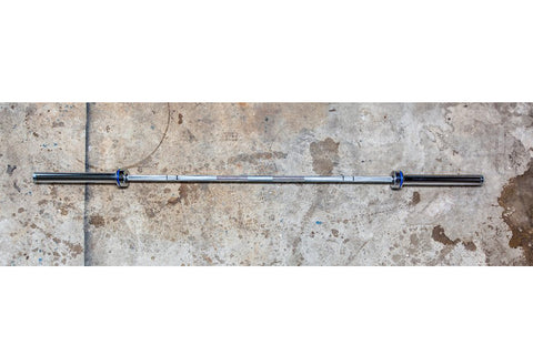 York Men's Elite Competition Olympic barbell with chrome finish, blue collar ring, and black shaft on concrete surface