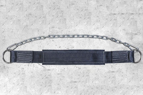 Metal chain dip belt with black nylon padding and webbing straps, flat lay on concrete background