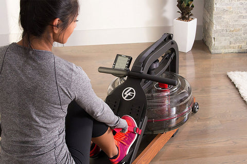 Life Fitness water rowing machine with wood base, black metal frame, padded seat, and transparent water tank on white backgro