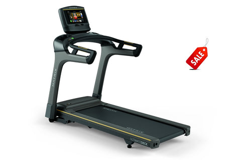 Matrix TF30 folding treadmill with gray and black frame, digital display console, dual handles, and black running deck on whi
