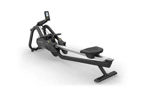 Black and silver Matrix rowing machine with digital console, footplate, and ergonomic handles on white background