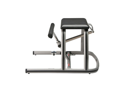 Gray and black pilates reformer chair with padded seat, horizontal foot bar, and metal frame on white background