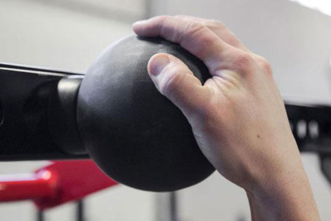 Hand holding black textured pull-up sphere grip training tool