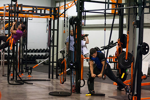 Purmotion FTS 200 Club Model Training Station with orange and black steel frame, multiple functional workout stations, and we