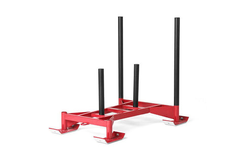 Red metal sled with four black vertical posts and wide base feet, professional training equipment on white background