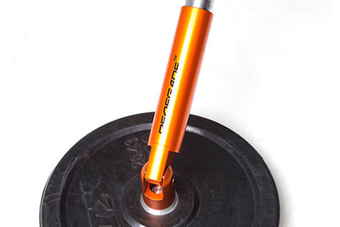 Orange anodized aluminum suspension fork with black rubber tire and silver hardware on white background