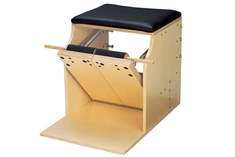 Natural wood Pilates chair with black padded seat, split pedal design, and adjustable straps on white background