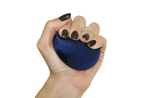 Dark blue sparkly stress ball held in hand with black nail polish on white background