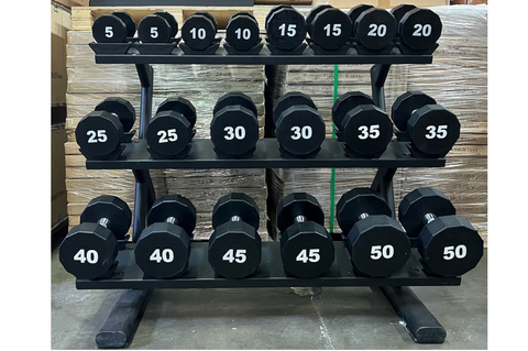 Black 12-sided urethane dumbbells arranged on tiered metal rack, labeled 5 to 50 pounds, in gym setting